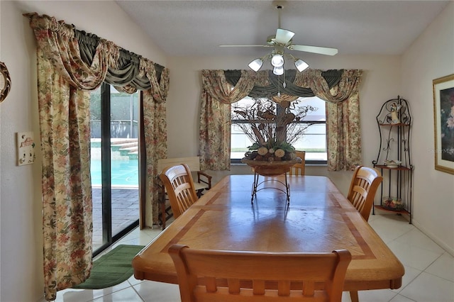 dining space with light tile patterned floors, vaulted ceiling, and a ceiling fan