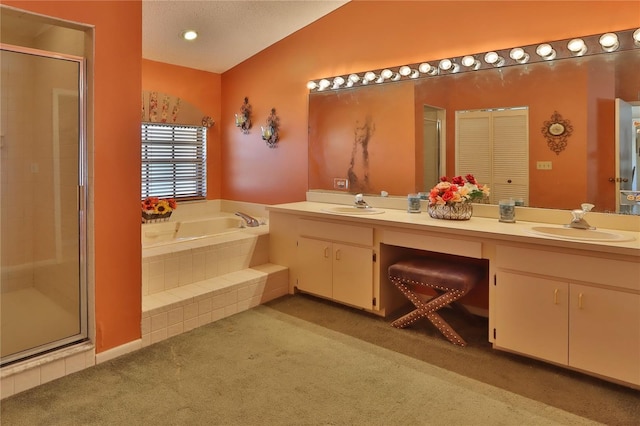 bathroom featuring double vanity, a shower stall, a sink, and a garden tub