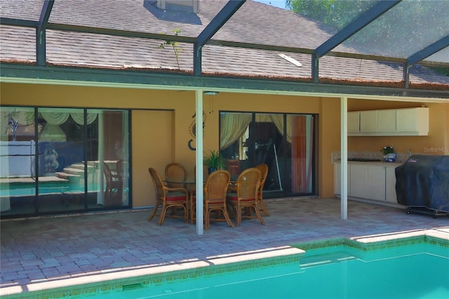 back of house featuring a patio, a lanai, and roof with shingles