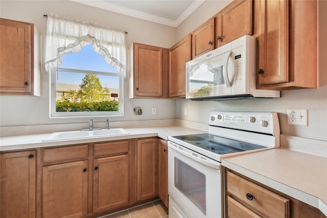 kitchen featuring white appliances, light countertops, ornamental molding, and a sink