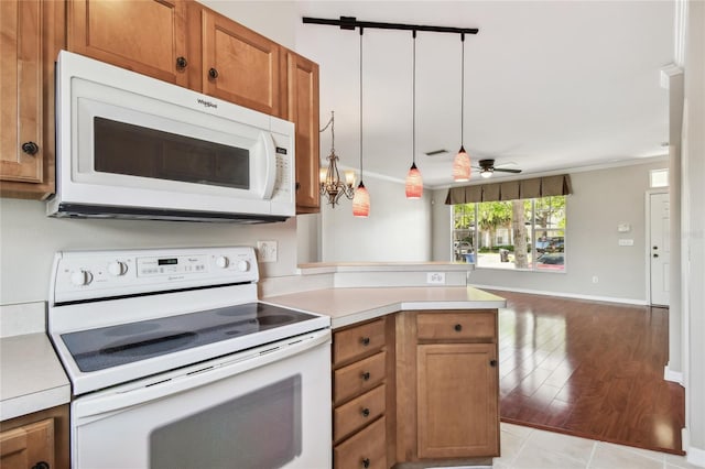 kitchen featuring brown cabinets, visible vents, light countertops, white appliances, and a peninsula