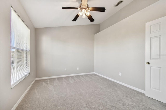 carpeted empty room featuring baseboards, visible vents, ceiling fan, and lofted ceiling