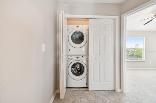laundry room with carpet floors, laundry area, baseboards, stacked washer and clothes dryer, and a ceiling fan