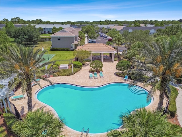 pool featuring a patio, fence, a gazebo, and a residential view
