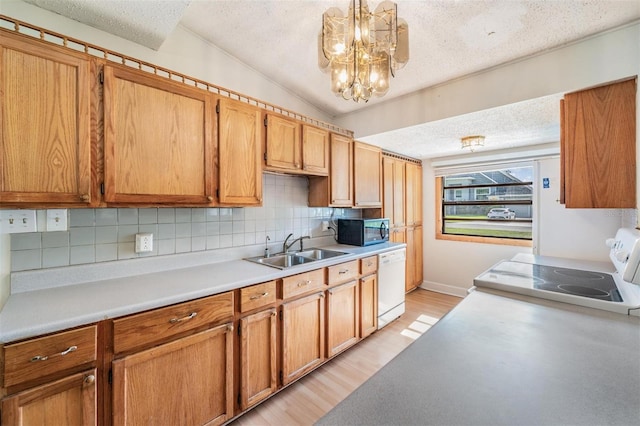 15808 Willowdale Rd, Tampa, FL 33625 - kitchen featuring white appliances, a textured ceiling, backsplash, light countertops, and light wood finished floors