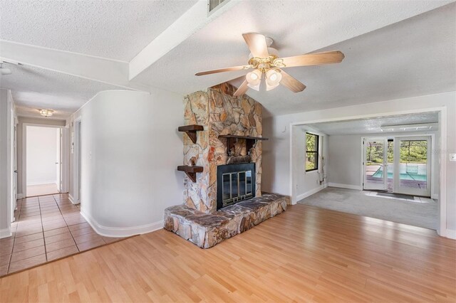 15808 Willowdale Rd, Tampa, FL 33625 - unfurnished living room featuring a textured ceiling, wood finished floors, ceiling fan, and a fireplace