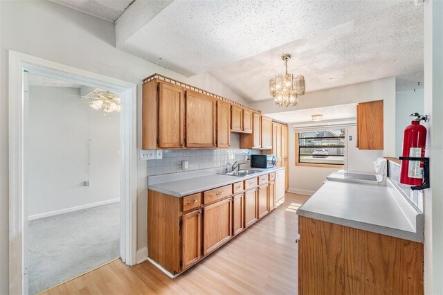 15808 Willowdale Rd, Tampa, FL 33625 - kitchen with light wood-style floors, a chandelier, decorative backsplash, light countertops, and stove