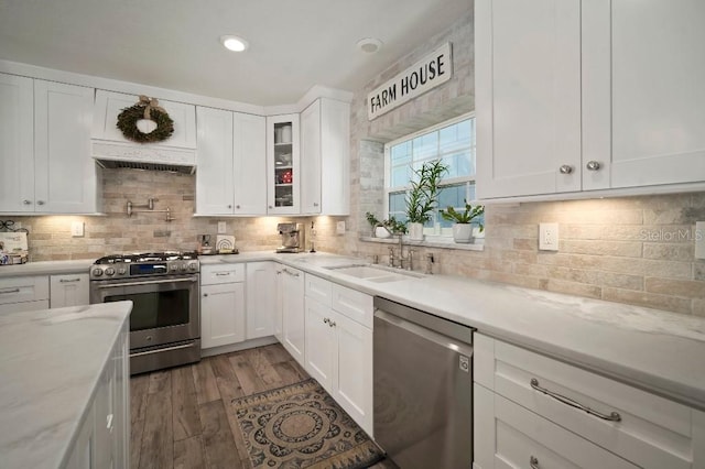 kitchen with white cabinets, backsplash, appliances with stainless steel finishes, and a sink
