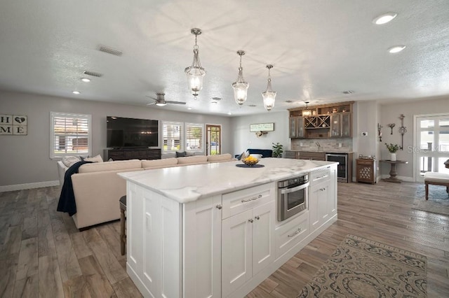 kitchen featuring wine cooler, recessed lighting, visible vents, and plenty of natural light