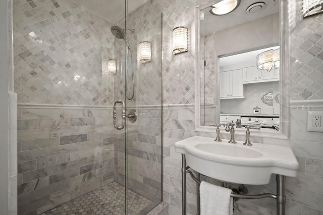 bathroom with a stall shower and tile walls