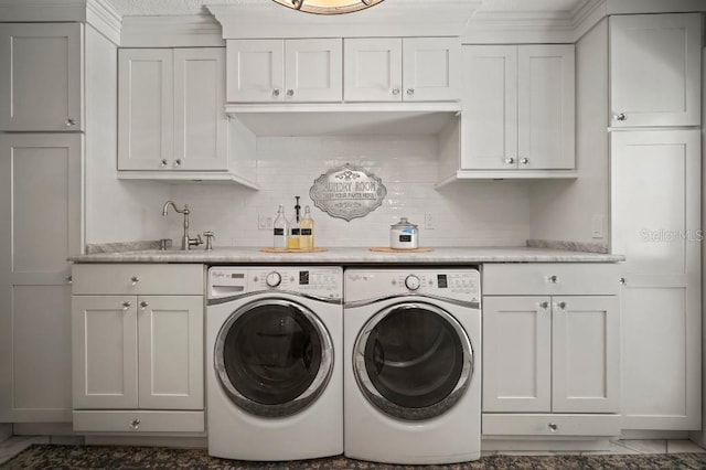 laundry room featuring separate washer and dryer, cabinet space, and a sink