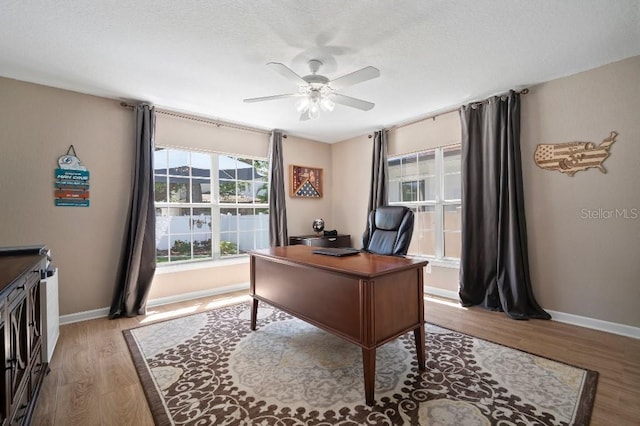 office area with wood finished floors, ceiling fan, and baseboards