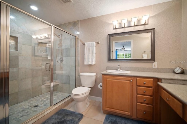 bathroom featuring a textured ceiling, a textured wall, a stall shower, toilet, and vanity