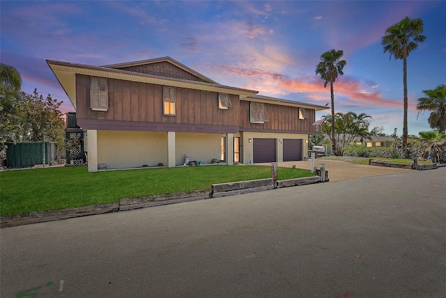 view of front facade featuring an attached garage, driveway, and a front lawn