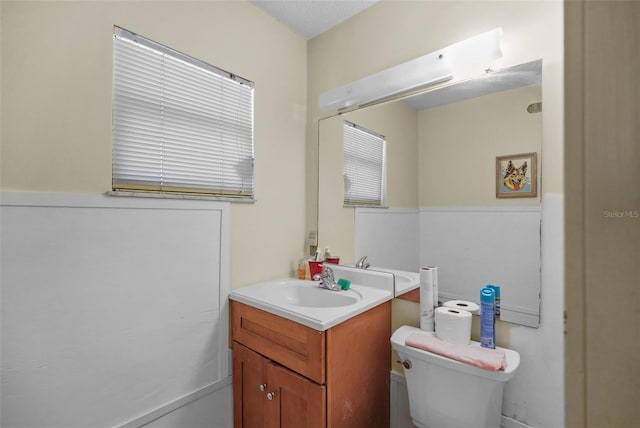 half bathroom featuring vanity and toilet