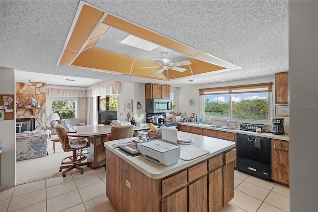 kitchen featuring a sink, appliances with stainless steel finishes, a kitchen island, and light countertops