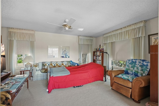 carpeted bedroom with a ceiling fan and a textured ceiling
