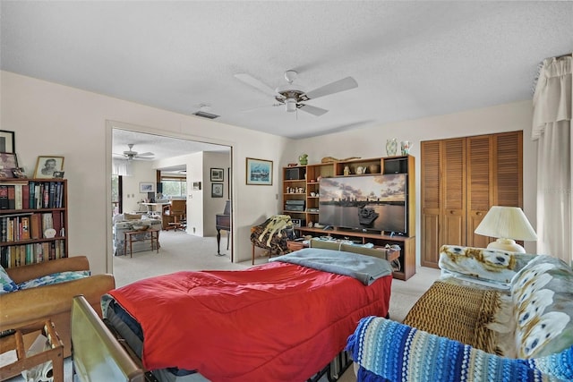bedroom featuring a ceiling fan, light colored carpet, visible vents, and a closet