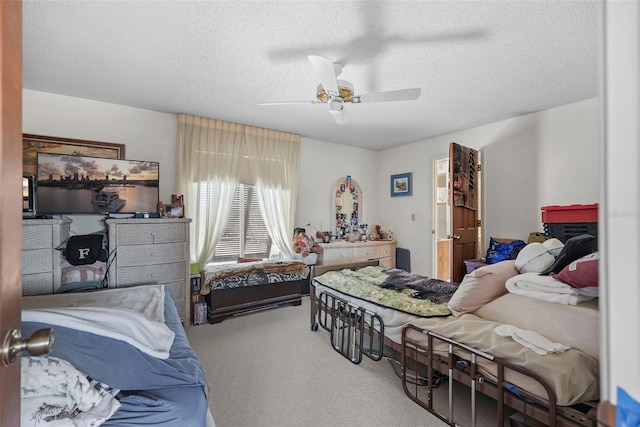 bedroom featuring ceiling fan, carpet, and a textured ceiling