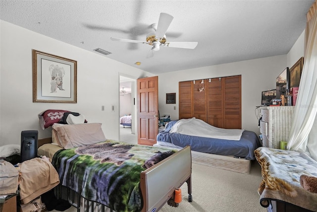 bedroom featuring ceiling fan, a textured ceiling, visible vents, a closet, and carpet