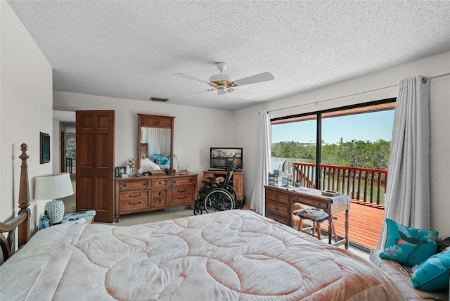 bedroom with access to outside, a textured ceiling, visible vents, and a ceiling fan