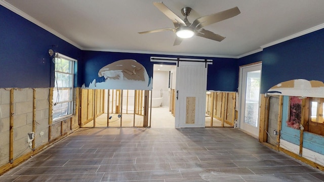 4511 Huntington St NE, Saint Petersburg, FL 33703 - spare room featuring crown molding, ceiling fan, a barn door, and wood finished floors