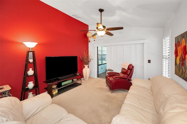 carpeted living room with ceiling fan and vaulted ceiling