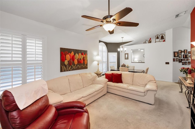 carpeted living room featuring vaulted ceiling, ceiling fan with notable chandelier, and visible vents
