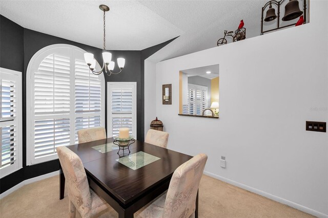 carpeted dining area with a textured ceiling, baseboards, and a notable chandelier