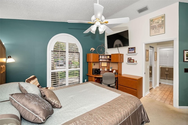 bedroom with ceiling fan, light carpet, a textured ceiling, baseboards, and visible vents