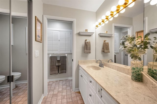 full bathroom with vanity, baseboards, and toilet