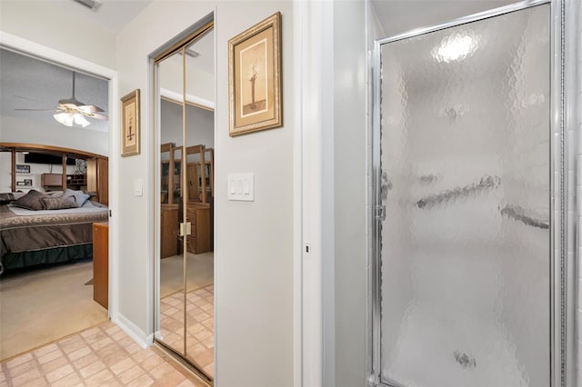 ensuite bathroom with a ceiling fan, tile patterned floors, and a shower stall