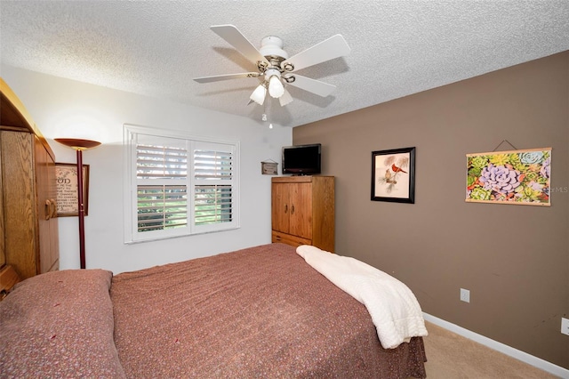 bedroom with ceiling fan, carpet flooring, and a textured ceiling