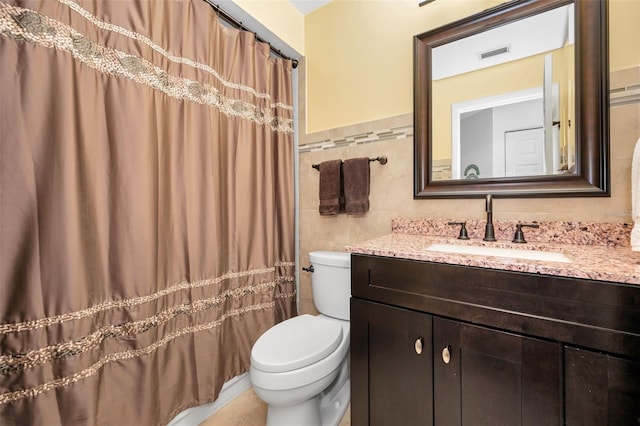 full bath with visible vents, tile walls, tile patterned floors, vanity, and toilet