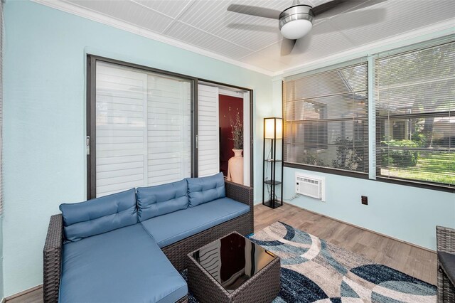 living area featuring ornamental molding, a ceiling fan, wood finished floors, and a wall mounted air conditioner