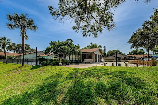 view of yard featuring fence and a sunroom