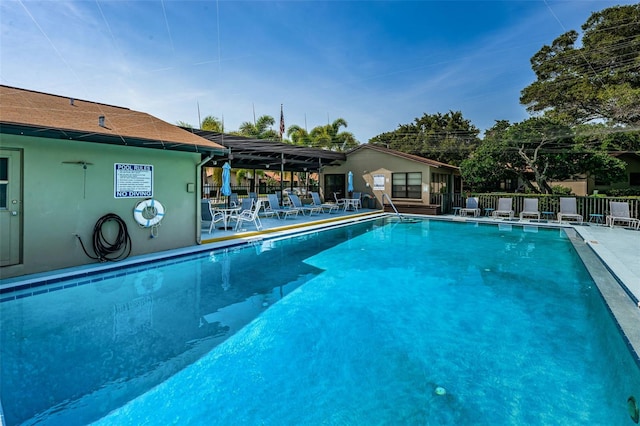 pool with a patio and fence