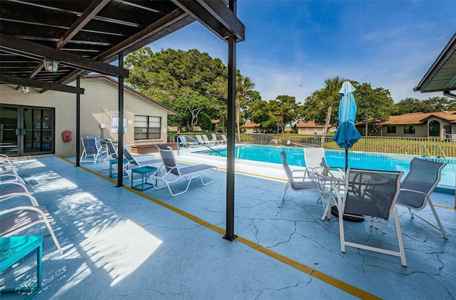 pool with a patio and fence