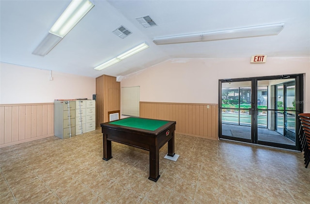 playroom featuring french doors, visible vents, vaulted ceiling, wood walls, and wainscoting