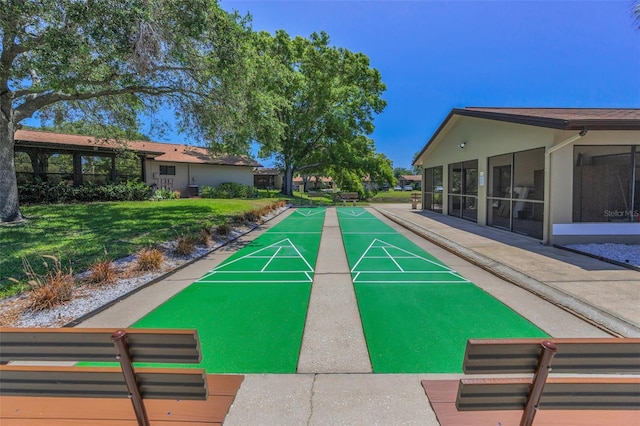 surrounding community with a lawn and shuffleboard