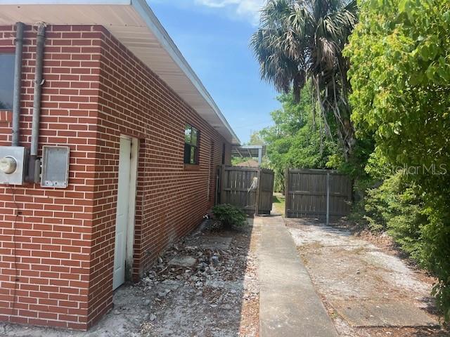 view of home's exterior featuring fence and brick siding