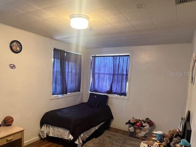 bedroom featuring dark wood finished floors and baseboards