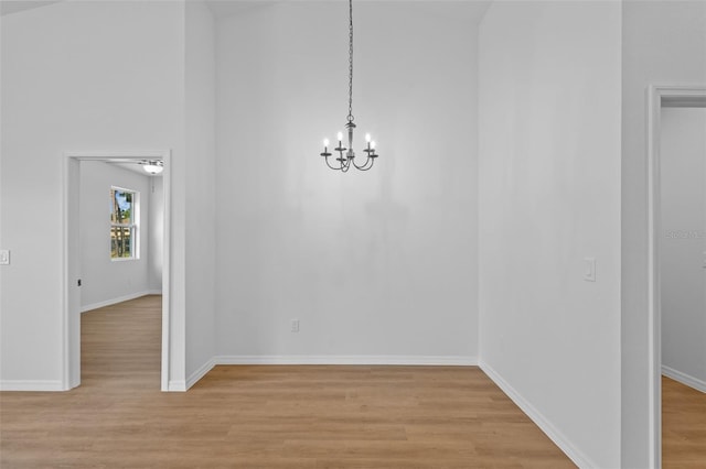 7603 Rhode Island Dr, Tampa, FL 33619 - unfurnished dining area with light wood-type flooring, baseboards, and a chandelier
