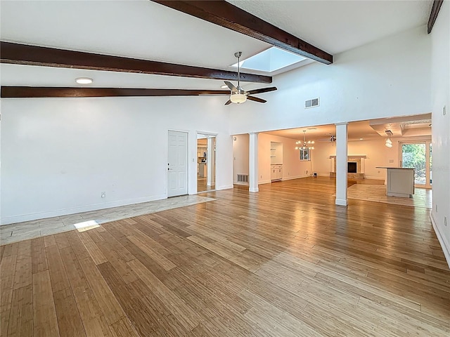 13891 Feather Sound Dr, Clearwater, FL 33762 - unfurnished living room featuring decorative columns, ceiling fan, light wood finished floors, beamed ceiling, and a chandelier