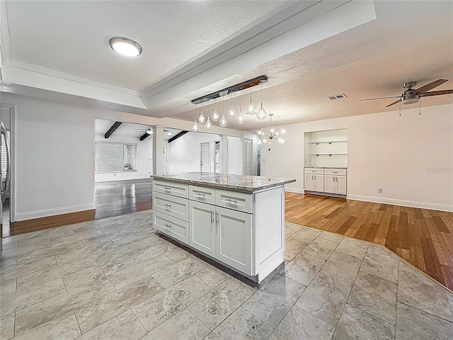 13891 Feather Sound Dr, Clearwater, FL 33762 - kitchen with ceiling fan, open floor plan, stone tile floors, a raised ceiling, and a textured ceiling