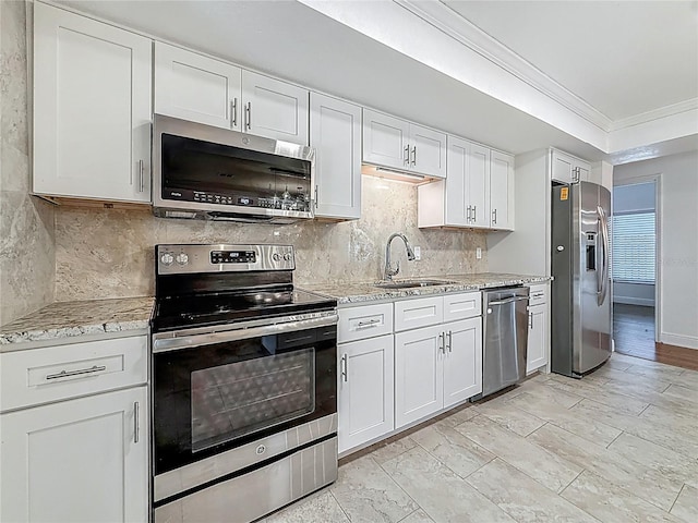 13891 Feather Sound Dr, Clearwater, FL 33762 - kitchen featuring stainless steel appliances, crown molding, tasteful backsplash, white cabinets, and light stone countertops