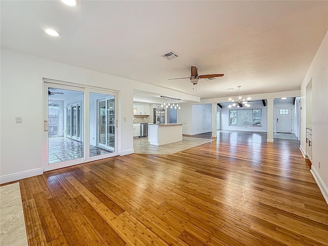 13891 Feather Sound Dr, Clearwater, FL 33762 - unfurnished living room with a chandelier, light wood finished floors, ceiling fan, and recessed lighting