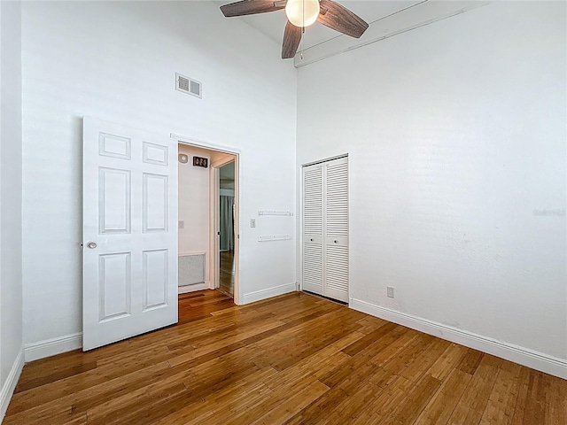 13891 Feather Sound Dr, Clearwater, FL 33762 - unfurnished bedroom with wood finished floors, a closet, a high ceiling, and a ceiling fan
