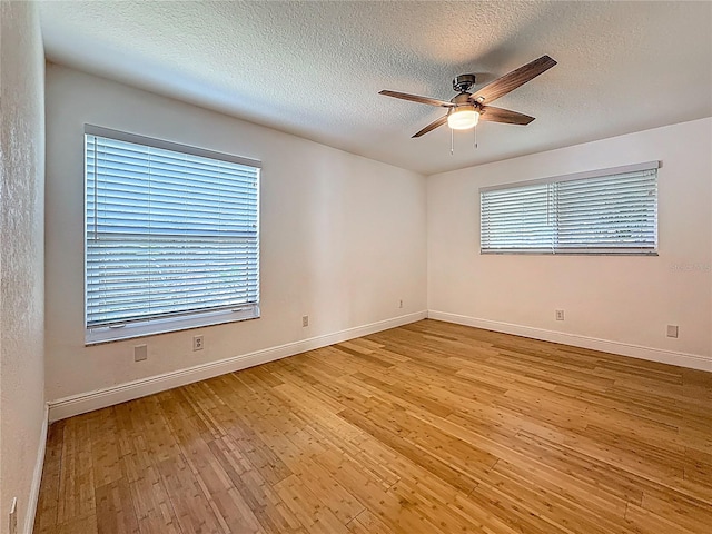 13891 Feather Sound Dr, Clearwater, FL 33762 - spare room featuring wood finished floors, ceiling fan, healthy amount of natural light, and a textured ceiling