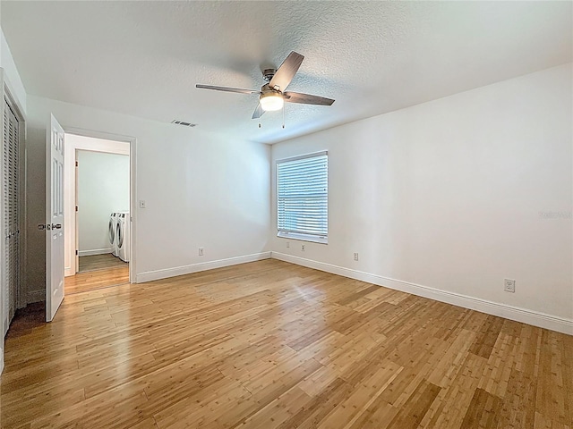13891 Feather Sound Dr, Clearwater, FL 33762 - unfurnished room featuring independent washer and dryer, light wood-type flooring, ceiling fan, and a textured ceiling